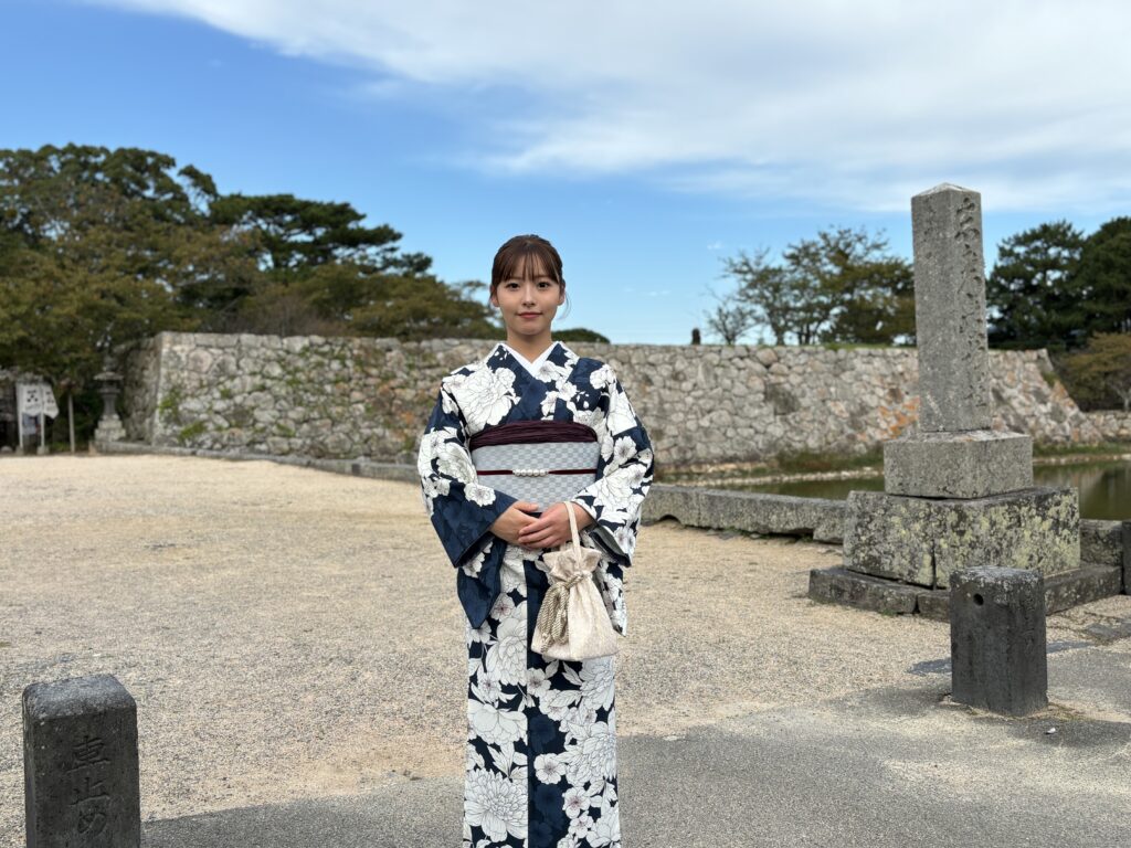 萩城跡の入り口の石垣前で紺色の着物姿